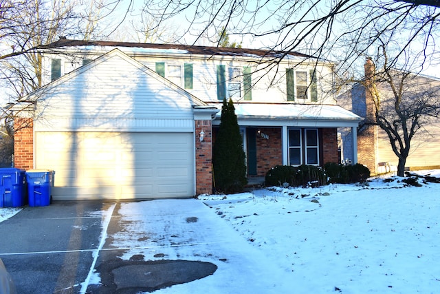 traditional-style house featuring a garage, driveway, brick siding, and covered porch