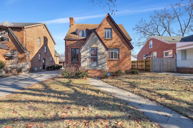 english style home featuring a front yard