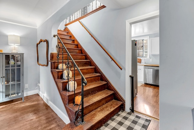 staircase with wood-type flooring and sink