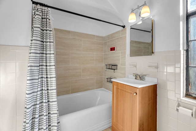 bathroom featuring shower / bath combination with curtain, vanity, and tile walls