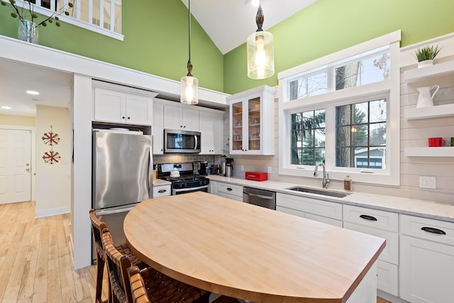 kitchen featuring decorative backsplash, sink, white cabinetry, and stainless steel appliances