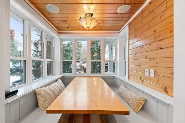 sunroom featuring breakfast area, plenty of natural light, and wood ceiling