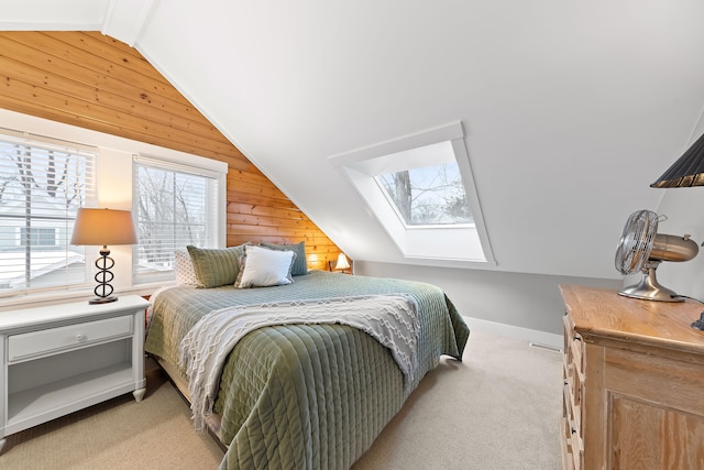 carpeted bedroom with wood walls and vaulted ceiling with skylight