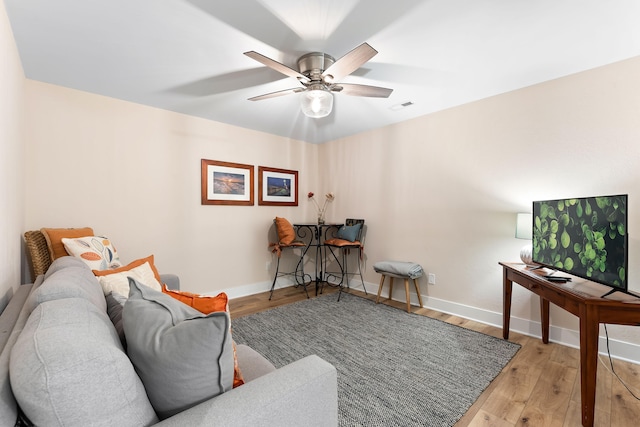 living room featuring light hardwood / wood-style flooring and ceiling fan