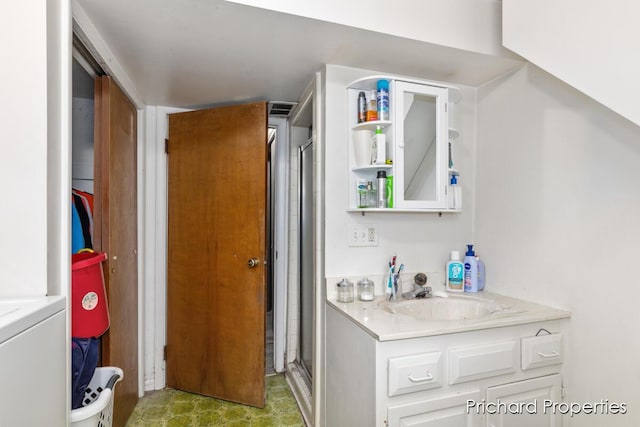 bathroom featuring vanity and a shower with door