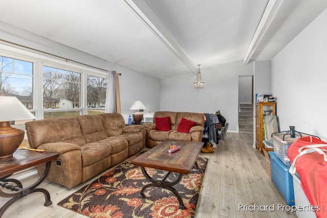 living room featuring lofted ceiling with beams and light hardwood / wood-style floors