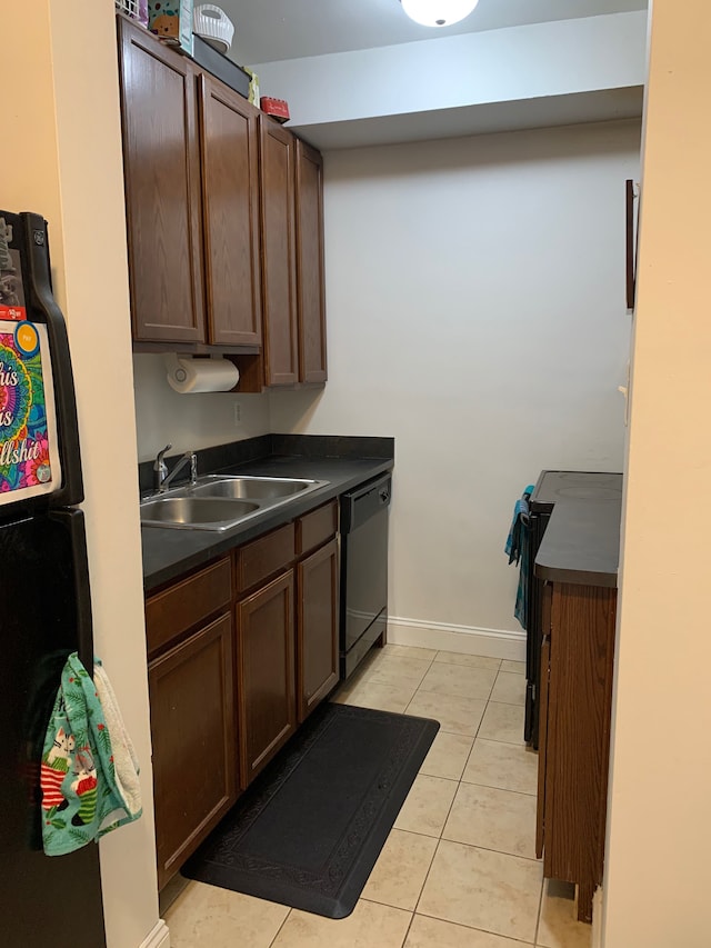 kitchen with sink, light tile patterned floors, black dishwasher, and dark brown cabinetry