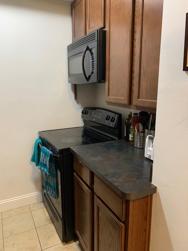 kitchen featuring light tile patterned flooring and black appliances