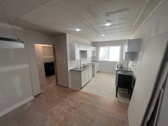 kitchen featuring washer / clothes dryer, white cabinetry, and sink