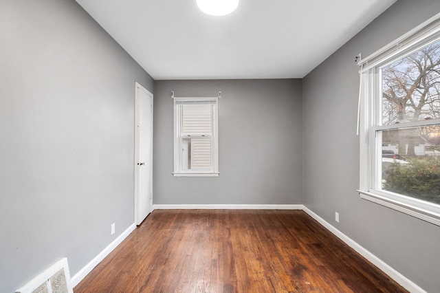 unfurnished room with dark hardwood / wood-style flooring