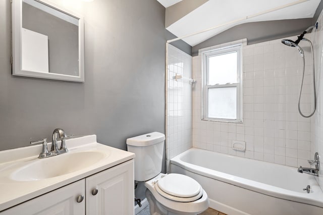 full bathroom featuring vaulted ceiling, vanity, tiled shower / bath combo, and toilet