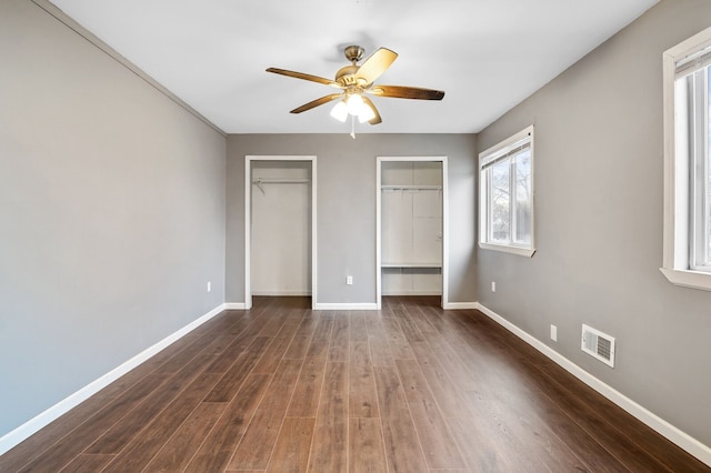 unfurnished bedroom with ceiling fan and dark hardwood / wood-style flooring