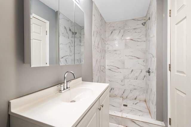 bathroom featuring tiled shower and vanity