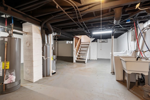 basement featuring washer and dryer, gas water heater, and heating unit