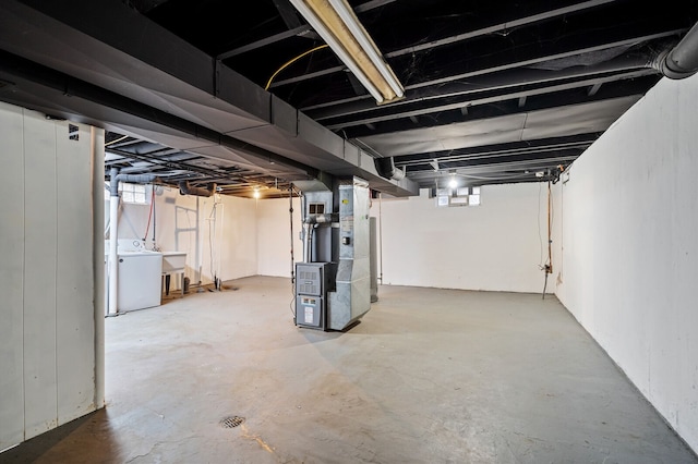 basement with washer / dryer, sink, and heating unit