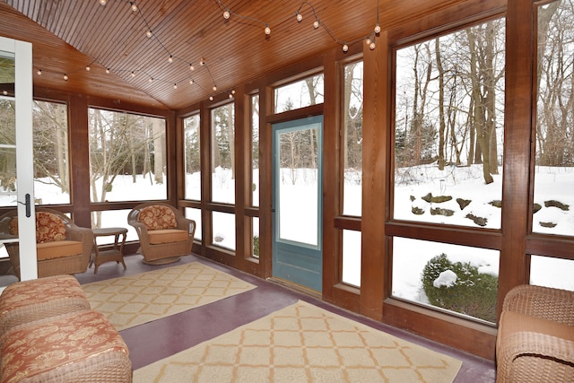 sunroom / solarium with vaulted ceiling, a wealth of natural light, and wood ceiling