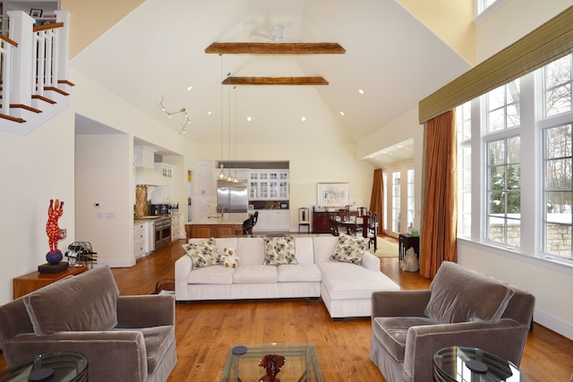 living room featuring high vaulted ceiling, beam ceiling, and light wood finished floors