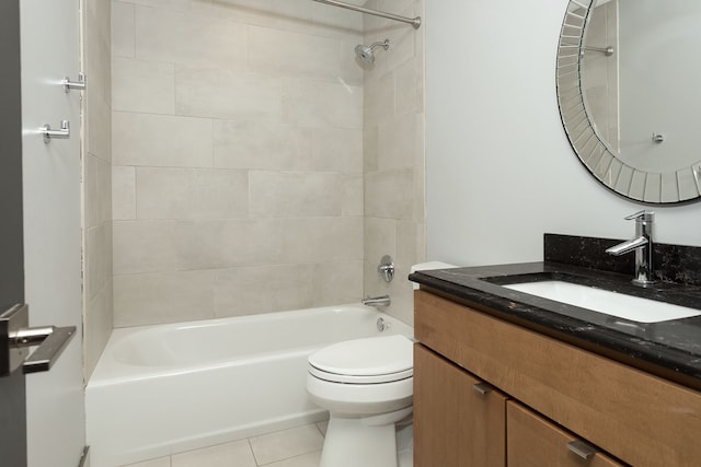 full bathroom with tile patterned floors, vanity, tiled shower / bath combo, and toilet