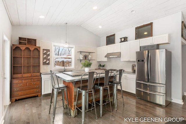 dining area featuring dark hardwood / wood-style flooring, lofted ceiling, sink, and wooden ceiling