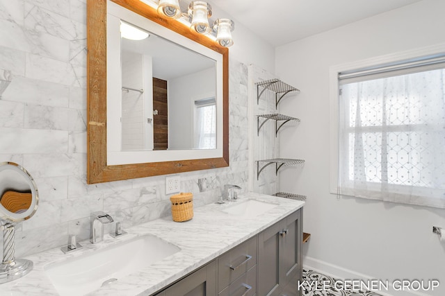 bathroom with decorative backsplash, vanity, and a healthy amount of sunlight