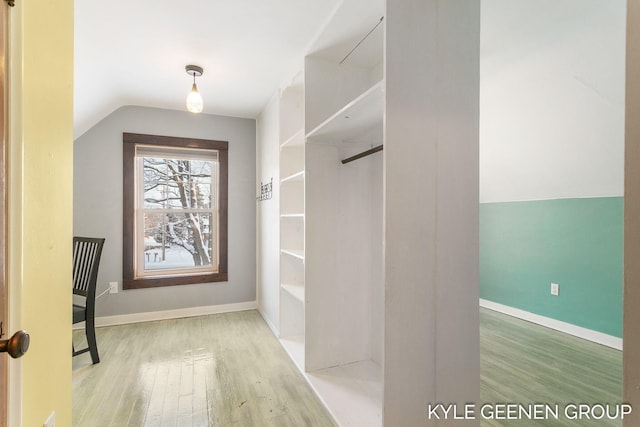 spacious closet featuring lofted ceiling and hardwood / wood-style flooring