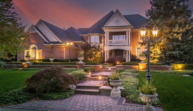 view of front of property with a lawn and a balcony