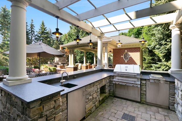 view of patio / terrace with ceiling fan, sink, exterior kitchen, a pergola, and area for grilling