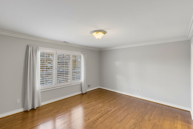 empty room featuring hardwood / wood-style flooring and crown molding