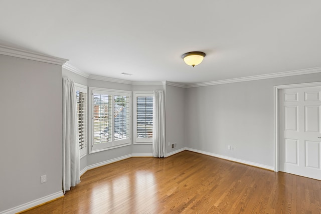 empty room featuring wood-type flooring and ornamental molding