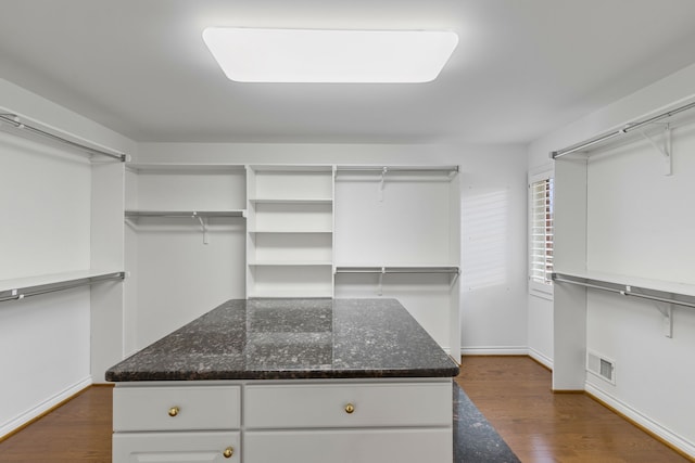 spacious closet featuring dark hardwood / wood-style flooring