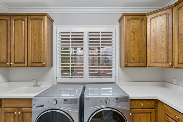 washroom featuring washer and dryer, ornamental molding, cabinets, and sink