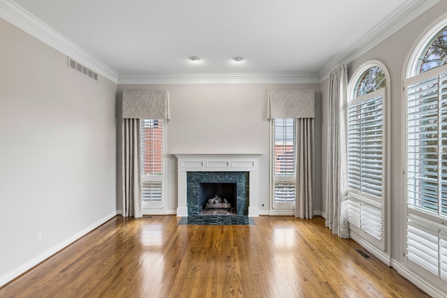 unfurnished living room featuring a high end fireplace, hardwood / wood-style floors, and ornamental molding