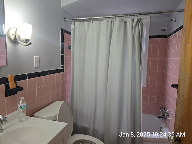 full bathroom with vanity, toilet, tile walls, and shower / tub combo with curtain