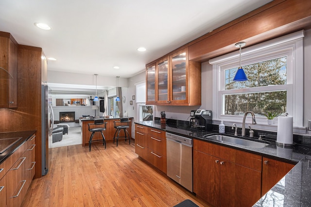 kitchen featuring sink, pendant lighting, appliances with stainless steel finishes, and dark stone counters