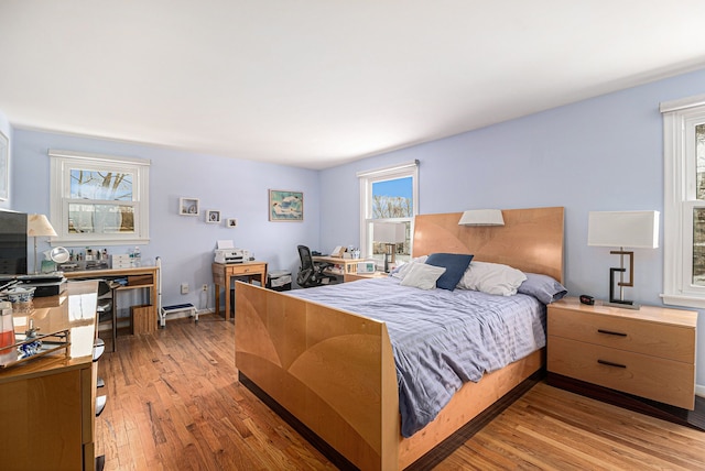 bedroom featuring multiple windows and hardwood / wood-style flooring