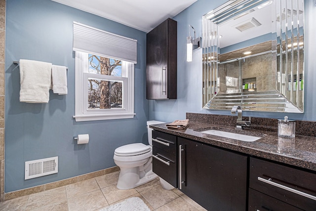 bathroom with toilet, tile patterned flooring, walk in shower, and vanity