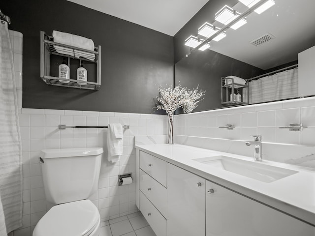 bathroom featuring vanity, tile patterned floors, toilet, tile walls, and curtained shower