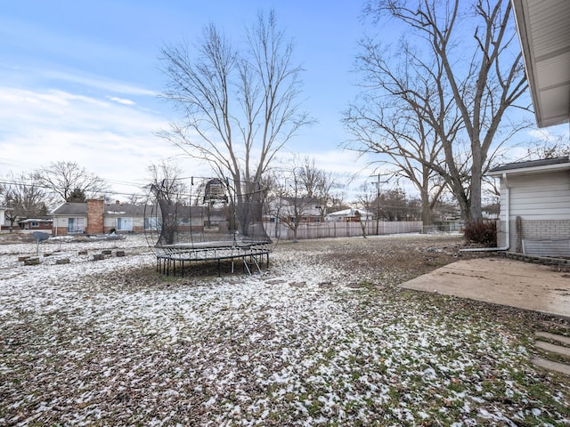 yard covered in snow with a trampoline