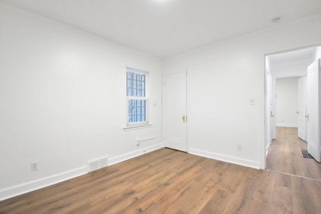 spare room featuring wood-type flooring