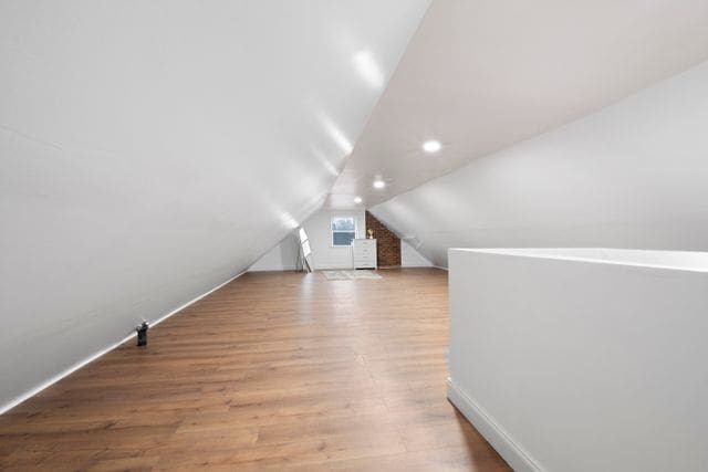 bonus room featuring light wood-type flooring and lofted ceiling