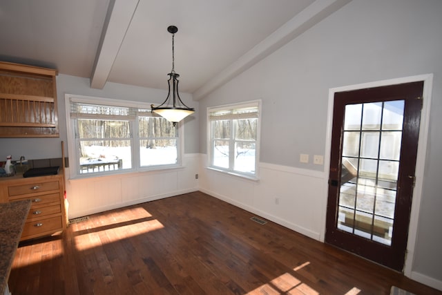 unfurnished dining area featuring dark wood-type flooring and vaulted ceiling with beams