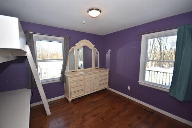 bedroom featuring dark hardwood / wood-style floors and multiple windows