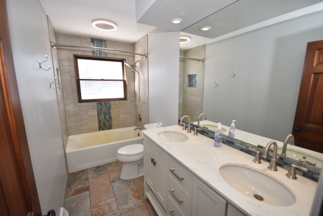 9417 Mabley Hill Rd, Fenton, MI 48430 - full bathroom with double vanity, shower / tub combination, a sink, and toilet
