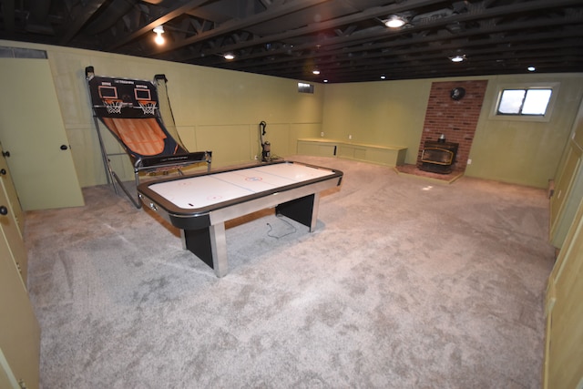 playroom featuring light carpet and a wood stove