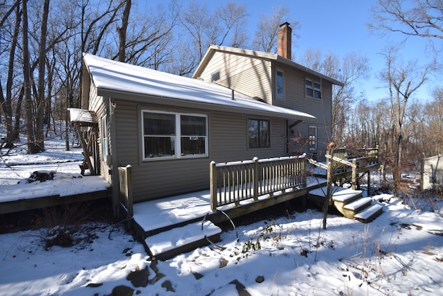 snow covered house with a deck