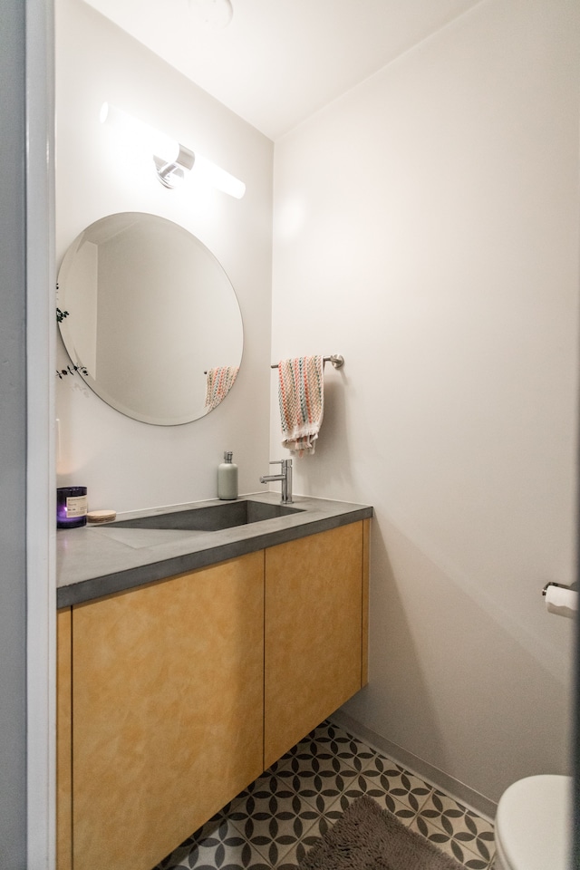 bathroom with tile patterned flooring, vanity, and toilet