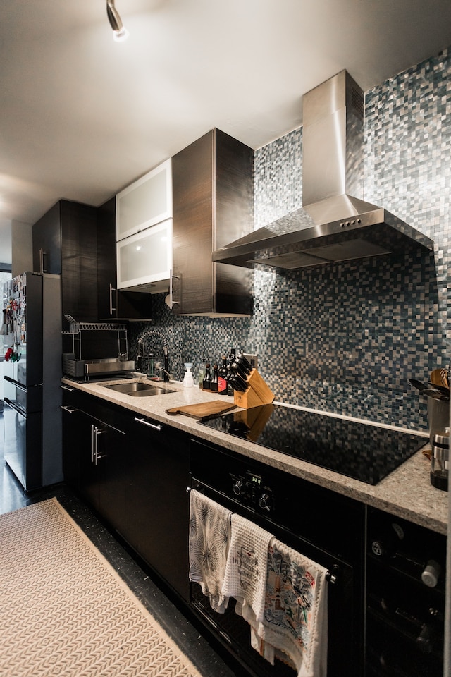 kitchen featuring decorative backsplash, sink, wall chimney exhaust hood, and black appliances