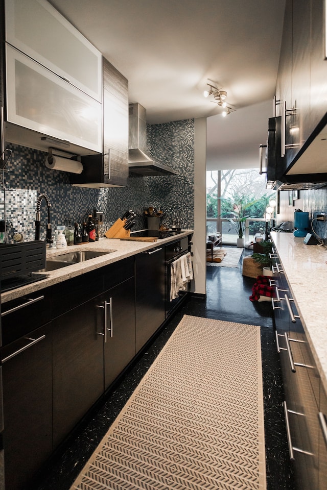 kitchen featuring backsplash, oven, sink, wall chimney exhaust hood, and stovetop