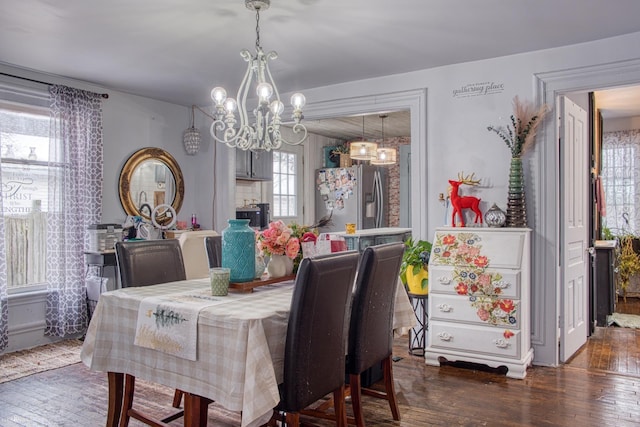 dining space with dark wood-type flooring and a notable chandelier