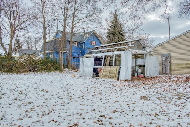 snow covered property with an outbuilding